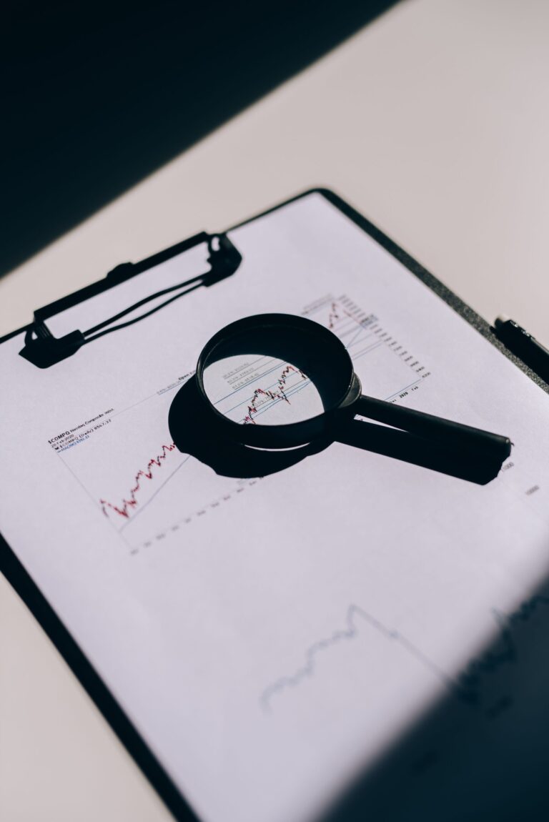 Magnifying glass over an audit report with a data chart
